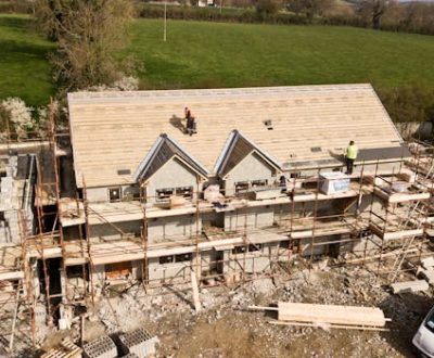 Aerial shot of a house under construction in Clonmel, Ireland. Workers on the roof.